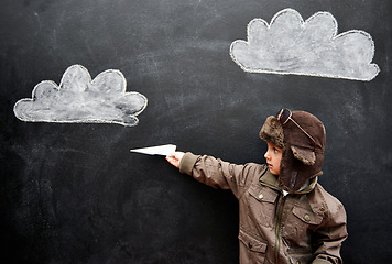 Image showing Children, chalkboard and paper plane with boy in studio on black background for fantasy game. Education, class and kid pilot in costume at playing school for growth, learning or child development