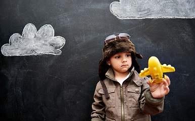 Image showing Kids, chalkboard and toy plane with boy in studio on black background for fantasy game. Education, imagine and class pilot in costume playing at school for growth, learning or child development