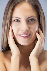 Image showing Woman, skincare and happy with portrait in studio for facial treatment, beauty glow and dermatology. Model, person and face with confidence for cosmetics, healthy skin and wellness on blue background