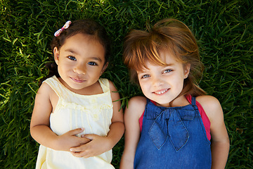 Image showing Happy, nature and girl children on grass play together in outdoor park or garden from above. Smile, bonding and high angle portrait of young kid friends relaxing in field lawn on holiday or weekend.