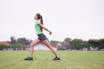 Image showing Sports, stretching and woman on field for exercise, workout and training for running outdoors. Fitness, park and person warm up for wellness, healthy body and exercising for performance and balance