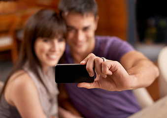 Image showing Love, smile and couple with selfie blur in house for bonding, photography or memory with care. Smartphone, profile picture or people embrace with romance at home for social media, blog or vlog update