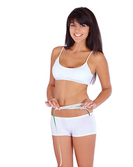 Image showing Woman, body and measure tape in studio for fitness, health and weight loss results of training progress. Portrait of model or person check stomach for exercise or workout goals on a white background