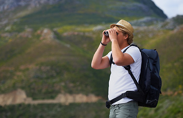 Image showing Man, hiker and binoculars with backpack for sightseeing, outdoor travel or hiking on mountain in nature.Young person, traveler or tourist with bag or optical instrument for view, vision or scope