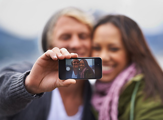 Image showing Phone screen, selfie and couple hug in nature for travel, freedom or road trip adventure together. Smartphone, photography and people with love in a forest for camping, journey or social media memory