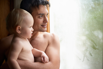 Image showing Window, rain and father with baby in house for bonding, playing or having fun in their home together. Water, glass or dad with curious kid watching storm, weather or raindrops for learning or games