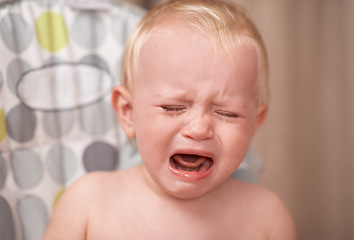 Image showing Baby, sad child and crying in home alone in nursery with colic, frustrated and unhappy. Young kid, toddler and tears of infant screaming for stress, depression and upset with face expression of pain