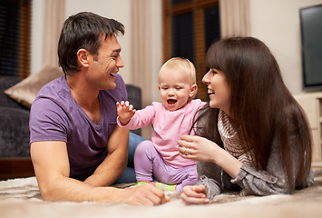 Image showing Love, baby and parents on a floor happy, laughing or playing while bonding in their home together, Family, support and excited kid with people in living room for child development, learning or games