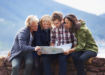 Image showing Happy people, friends and map on stone wall for direction, location or planning next destination. Young group looking or checking route, path or spot for holiday weekend or outdoor vacation in nature
