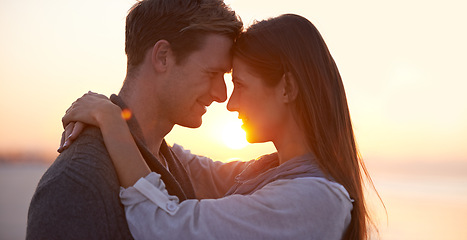 Image showing Couple, forehead touch on beach and sunset, nature and travel with bonding for love and commitment outdoor. People with support, trust and hug with adventure together for honeymoon or anniversary