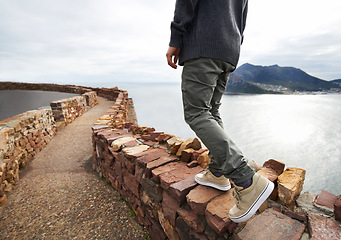 Image showing Person, legs and mountain cliff at ocean for explore nature for vacation journey or adventure, walking or relax. Shoes, path and hill in South Africa for holiday for outdoor tourist, travel or sea