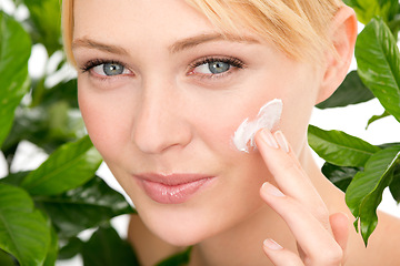 Image showing Portrait, skincare and woman with cream by leaves isolated on a studio background for health or hydration. Face, cosmetics and natural model with lotion for organic facial moisturizer or dermatology