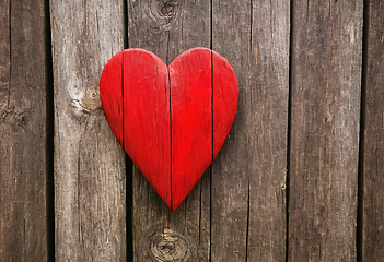 Image showing Bright red heart as a symbol of love and friendship on wooden wa