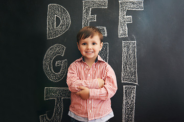 Image showing Child, boy and portrait with smile by blackboard with letters, alphabet or drawing in classroom at school. Kid, student and happy for knowledge, learning and chalkboard with illustration or preschool