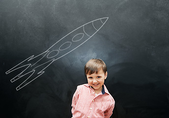 Image showing Child, boy and portrait or happy by blackboard with drawing, missile and creative fun in classroom at school. Kid, student and smile for illustration, education or chalkboard with mockup at preschool