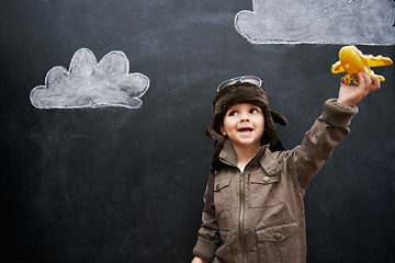 Image showing Child, boy and happy by blackboard with plane for creative fun, playing and drawing of clouds for education. Student, kid and confidence with airplane, chalkboard or illustration for knowledge or sky