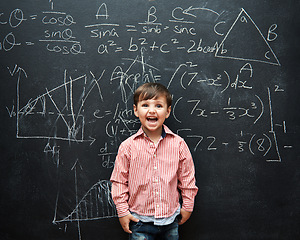 Image showing Child, boy and face or excited by blackboard with letters, numbers and education in classroom at school. Kid, student and happy for knowledge, learning and chalkboard with math, drawing and preschool