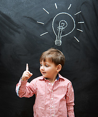 Image showing Child, solution and lightbulb on chalkboard for ideas, learning and education in school with answer or questions. Happy kid, student or boy with light bulb, emoji and creative knowledge on blackboard