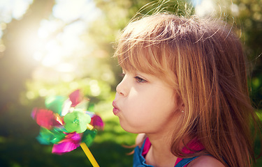 Image showing Young girl, outside and pinwheel in garden, fun and enjoy freedom of outdoor and profile. Child, backyard and summer for playing, toy and windmill for nature vacation or holidays and happiness