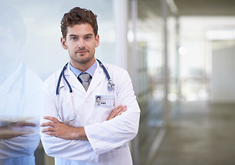 Image showing Doctor, man and portrait with arms crossed in hospital with healthcare for wellness, medicine and stethoscope by window. Medical, professional and expert with face for diagnosis, health and service