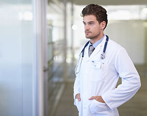 Image showing Doctor, man and thinking in hospital with healthcare for wellness, medicine and surgery with stethoscope by window. Medical, professional and expert with ideas for diagnosis, health and decision