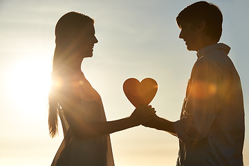 Image showing Silhouette, couple and happy with heart shape in nature, commitment and love symbol for marriage by blue sky. Man, woman and valentines day on romantic date and lens flare for bonding on honeymoon