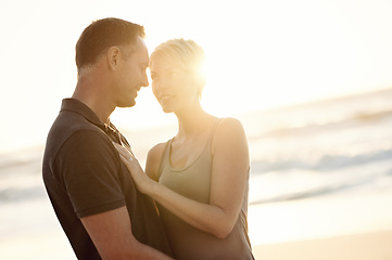 Image showing Couple, face and happy on beach with love for bonding, honeymoon date and weekend holiday with sunset. Lens flare, man and woman with embrace, smile and care for vacation, travel and adventure at sea