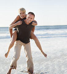 Image showing Couple, portrait and happy on beach with piggyback for bonding, honeymoon date and weekend holiday. Face, man and woman with embrace, smile and love in water by sea for vacation, travel and adventure