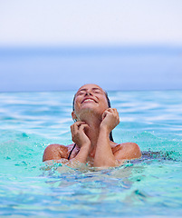 Image showing Face, smile and summer with woman in swimming pool for travel, holiday or vacation on blue sky. Tropical, wellness and wet with happy young swimmer person in water to relax at resort for getaway