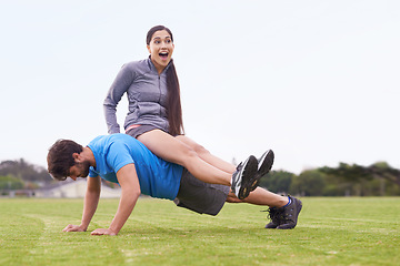 Image showing Man, push up and woman sitting on back with laugh, training or strong with balance in nature. Couple, exercise and workout on grass with smile, muscle or crazy with funny joke for fitness in England