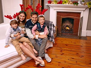 Image showing Christmas, portrait and happy family on sofa in home for holiday or festive celebration. Xmas, parents and smile of children in living room with antlers, bonding and kids together at party in house