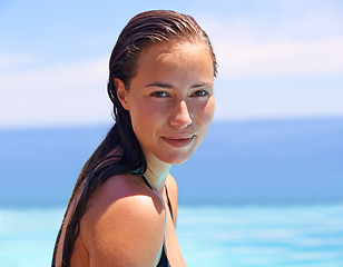 Image showing Portrait, summer and swimming pool with woman tourist outdoor for holiday or vacation to relax on blue sky. Face, travel and wet with confident young swimmer person in water for resort getaway