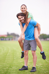 Image showing Couple, piggy back and exercise in park with portrait, smile and bonding with health in nature on grass. People, man and woman with care, support and laughing on lawn for training together in England