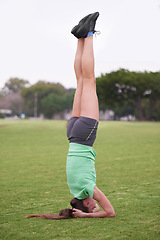 Image showing Headstand, sport and woman with fitness in a park with balance for wellness and health. Training, workout and outdoor on a field with exercise on a lawn with pilates and strong core practice