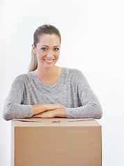 Image showing Portrait, moving and woman with a box, home and model isolated on a white studio background. Face, person and girl with property and real estate with renovation and achievement with package or parcel