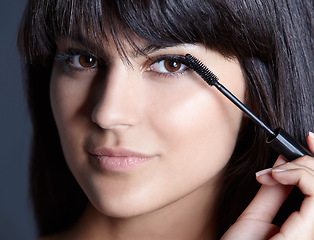 Image showing Beauty, skincare and portrait of woman with mascara for natural makeup, facial and studio. Lashes, application and cosmetics with face of girl isolated on blue background with brush, tools and pride.