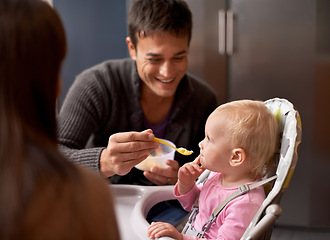 Image showing Happy, baby and dad in feeding at home in the morning with nutrition and wellness. Father, family and food of a infant with development and breakfast in a house kitchen with love, support and care