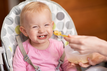 Image showing Happy, baby and laughing from feeding in high chair at home in the morning ready for eating food. Youth, funny and smile of a infant with development and laughter in house with fun and joy of a child