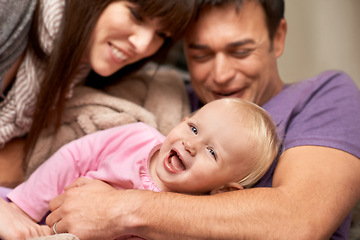 Image showing Love, hug and baby with parents in a house for playing, tickle or games while bonding in laughter. Happy family, face and kid with funny people in living room with support, trust or child development