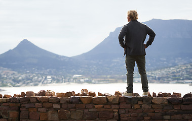 Image showing Man, watching mountains and thinking of adventure ideas and inspiration in Cape Town, South Africa. Male person and natural scenery for contemplating, planning and explore on wall with mock up