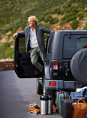 Image showing Man, car and looking out door on road trip for travel, break or stop in nature or sightseeing. Young or handsome male person, tourist or traveler exploring or enjoying view or holiday from vehicle