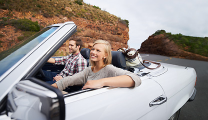 Image showing Happy couple, car and driving on road trip for travel, holiday weekend or outdoor vacation on street in nature. Young man and woman with smile for transportation or getaway in convertible vehicle