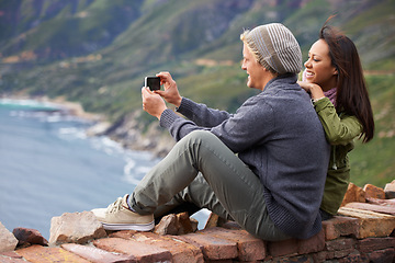 Image showing Happy couple, selfie and photography in nature on mountain for picture, memory or outdoor vlog. Rear view of man and woman smile for photo, social media or bonding moment outside on cliff or wall