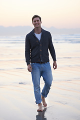 Image showing Man, walking and happy in portrait by ocean, sunset and vacation with nature to relax at beach. Person, travel and outdoor by sea with feet in sand for holiday, adventure or smile by sea in Australia