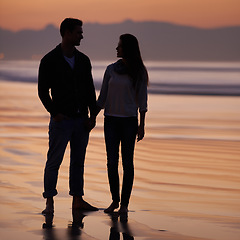 Image showing Couple, holding hands on beach and sunset, nature and travel with bonding for love and commitment outdoor. People with support, trust and loyalty with adventure together for honeymoon or anniversary