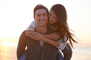 Image showing Portrait, piggy back and couple at ocean at sunset for tropical holiday adventure, relax and bonding outdoor. Love, happy man and woman on romantic date with beach, evening sky and vacation together