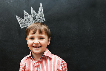 Image showing Boy, portrait and crown on chalkboard with smile from cute learner in preschool. Young student, happy and learning in classroom for education in art for development of creativity for youth