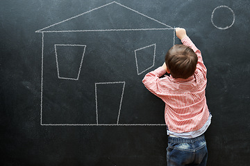 Image showing Kid, drawing and art of house on chalkboard of preschool as young student in classroom. Little boy, creative and imagination for sketch of home on dark background of blackboard for real estate