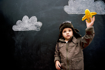 Image showing Child, boy and face by blackboard with plane for creative fun, playing or drawing of clouds for imagination. Student, kid and confidence with airplane, chalkboard or illustration for knowledge or sky