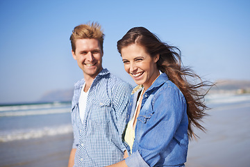 Image showing Couple, laugh and walk on beach for romantic date on sunny afternoon with blue sky in Australia. Big smile, man and woman in love for sweet relationship, fun dating and bonding together in summer